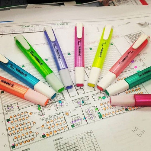Hand holding Stabilo Swing Cool turquoise highlighter over an open notebook