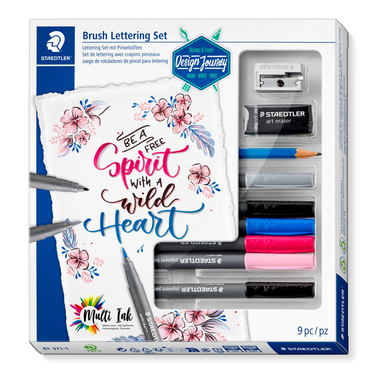 Staedtler Design Journey Brush Lettering Set box with a floral be a free spirit lettering card, and a window showing the sharpener, eraser, pencil and six pens