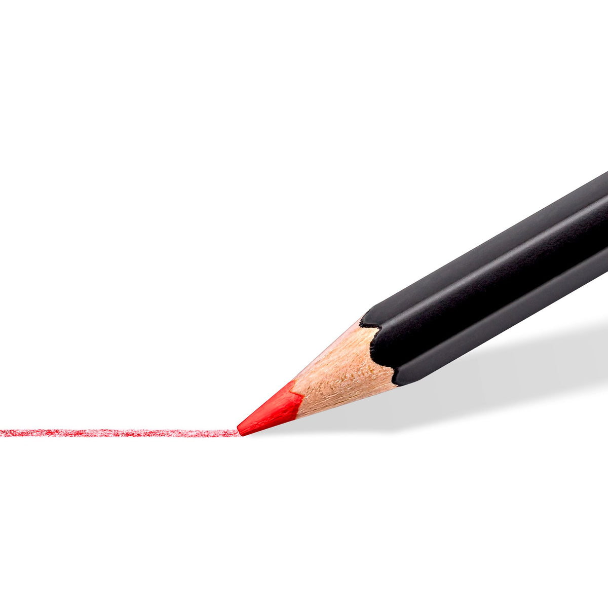 Close view of a black-barrel super soft pencil laying a bright red line on white paper