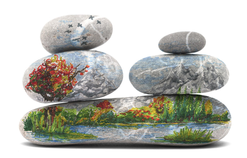 Finished Staedtler painted stone stack: autumn tree, lake and reeds, plus blue sky and flying birds added to the upper pebbles