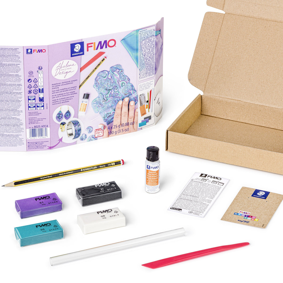 Contents of the FIMO abalone design set: four clay half blocks, a small gloss varnish bottle, roller, modelling stick, pencil and leaflet