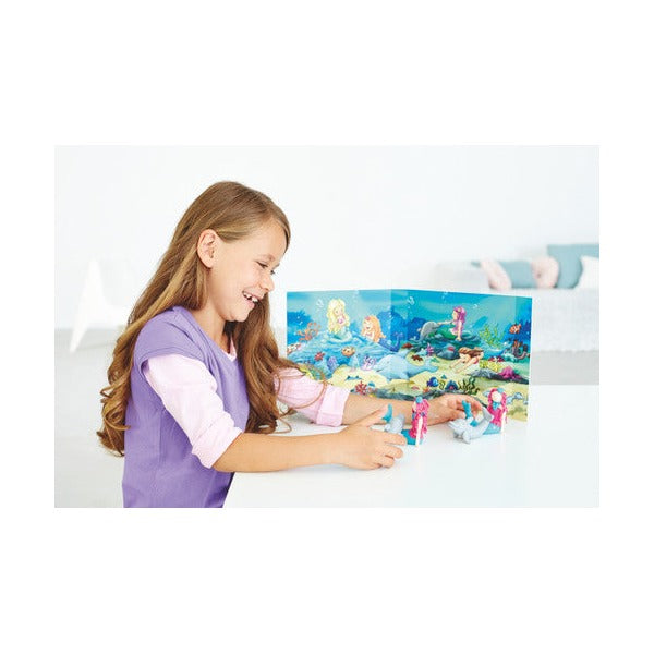 Girl playing with clay sea creatures in front of the underwater backdrop