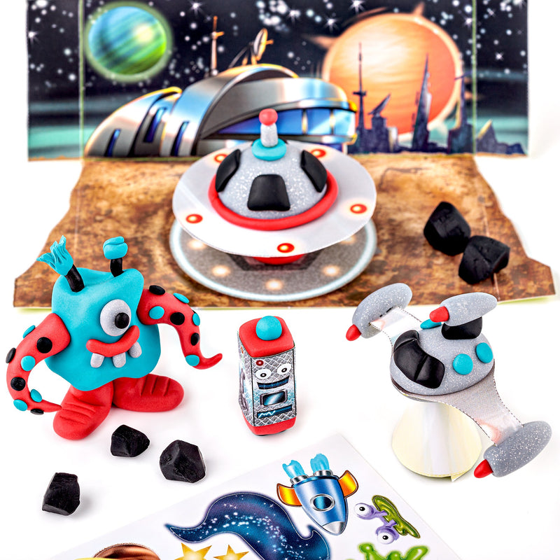 Finished Space set models: a turquoise and red one-eyed alien, a flying saucer and a silver robot on a planet surface in front of the backdrop