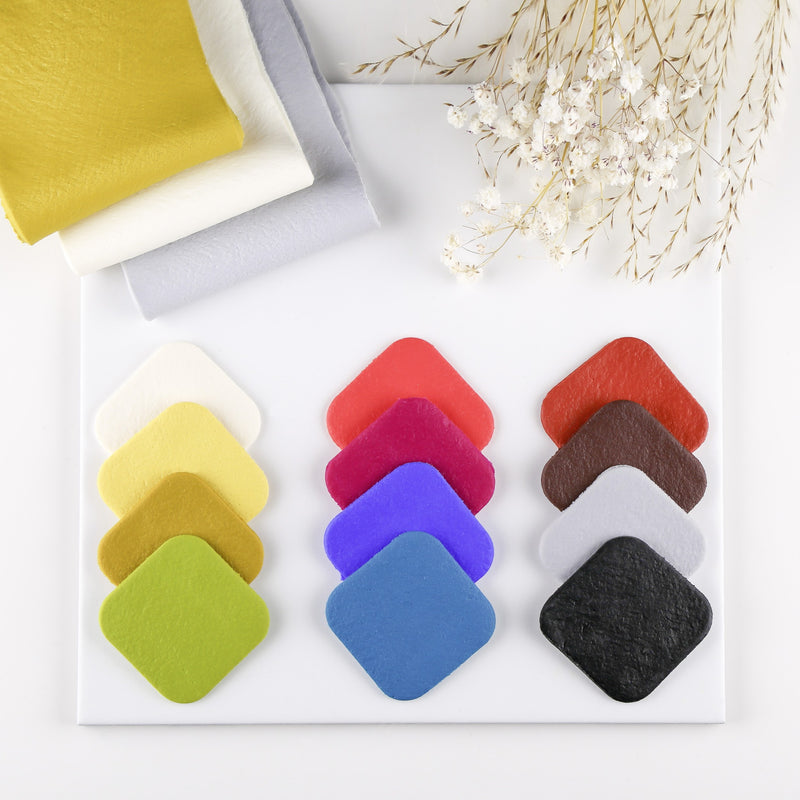 Diamond-shaped swatches of FIMO leather-effect colours laid out beside folded sheets of baked leather-look clay