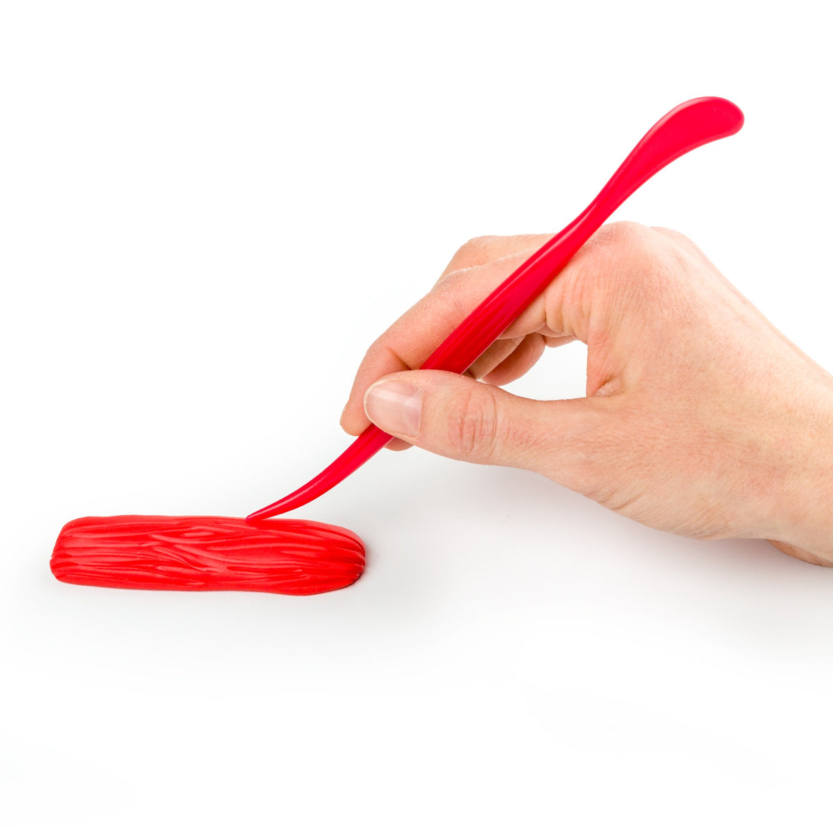 Hand smoothing a coil of red clay with the curved spatula end of a FIMO modelling stick
