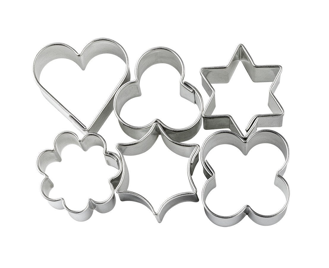 Six FIMO metal shape cutters out of the bag: heart, clover, six-point star, flower, curved star and four-petal shape