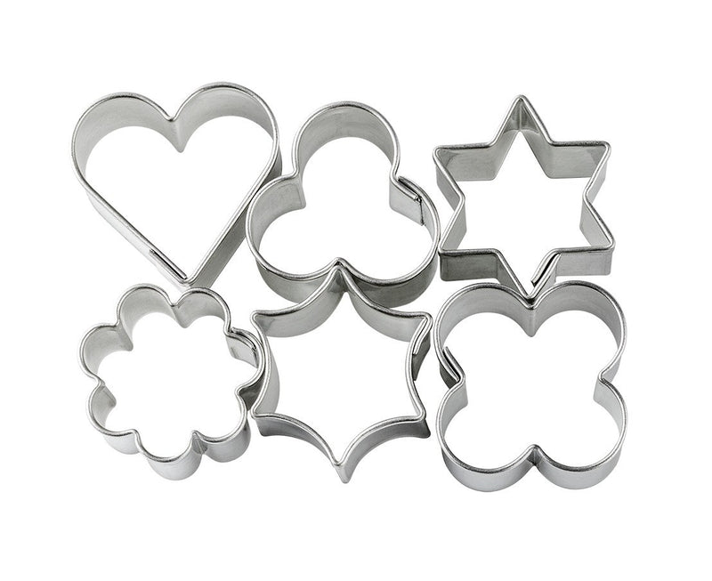 Six FIMO metal shape cutters out of the bag: heart, clover, six-point star, flower, curved star and four-petal shape