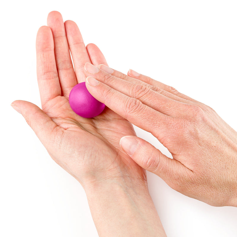 Pink FIMO soft rolled into a ball between two palms, a Staedtler range photo of the modelling clay