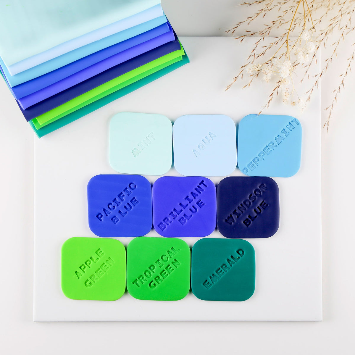 Stamped clay tiles on a Staedtler board: mint, aqua, peppermint, three blues, apple green, tropical green and emerald