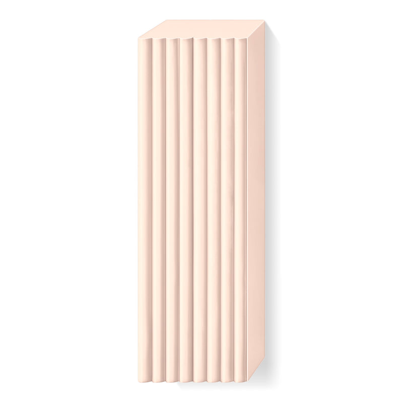 Pale pink FIMO soft large block out of its wrapper, showing the scored lines that divide it into portions