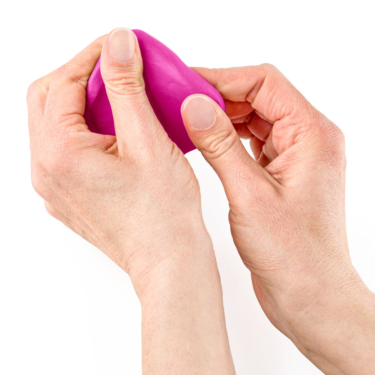 Hands working a lump of magenta FIMO soft clay, a Staedtler range photo of the soft clay being kneaded