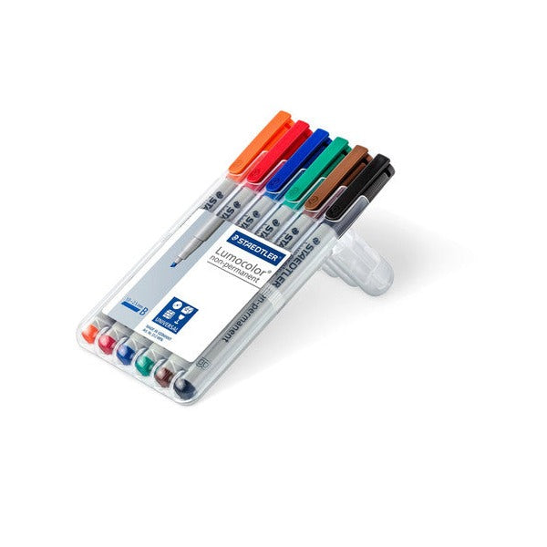 Open Staedtler Lumocolor 312 WP6 box propped up as a stand, holding orange, red, blue, green, brown and black broad pens