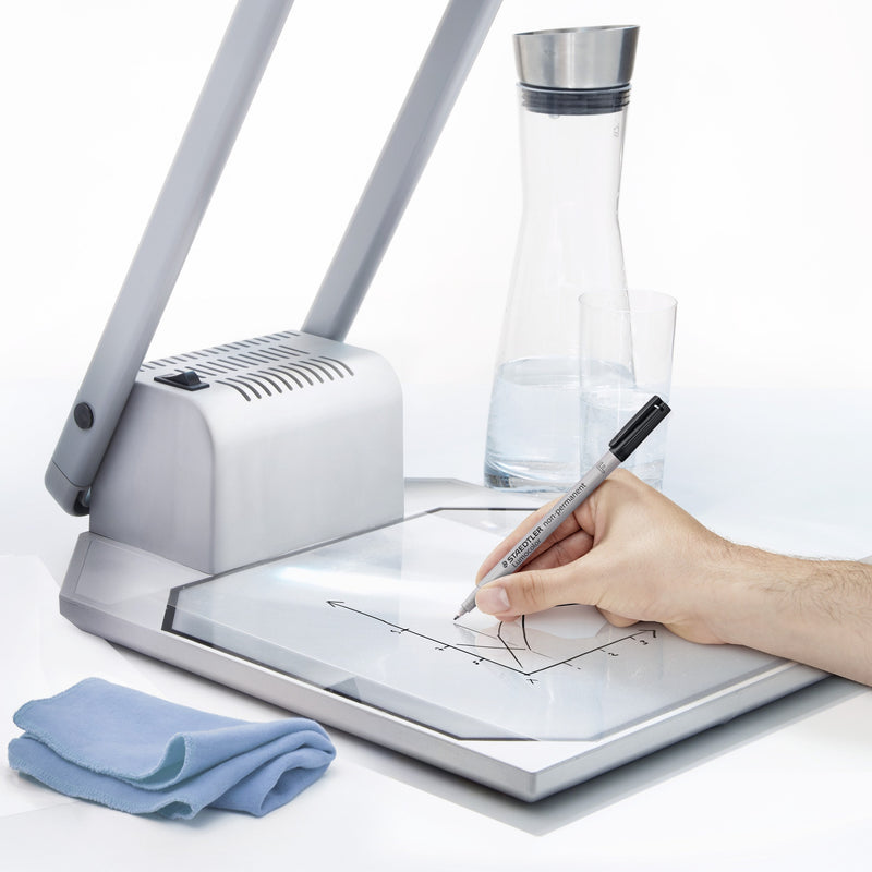 Staedtler photo of a hand writing on an overhead projector with a black Lumocolor pen and a blue cleaning cloth