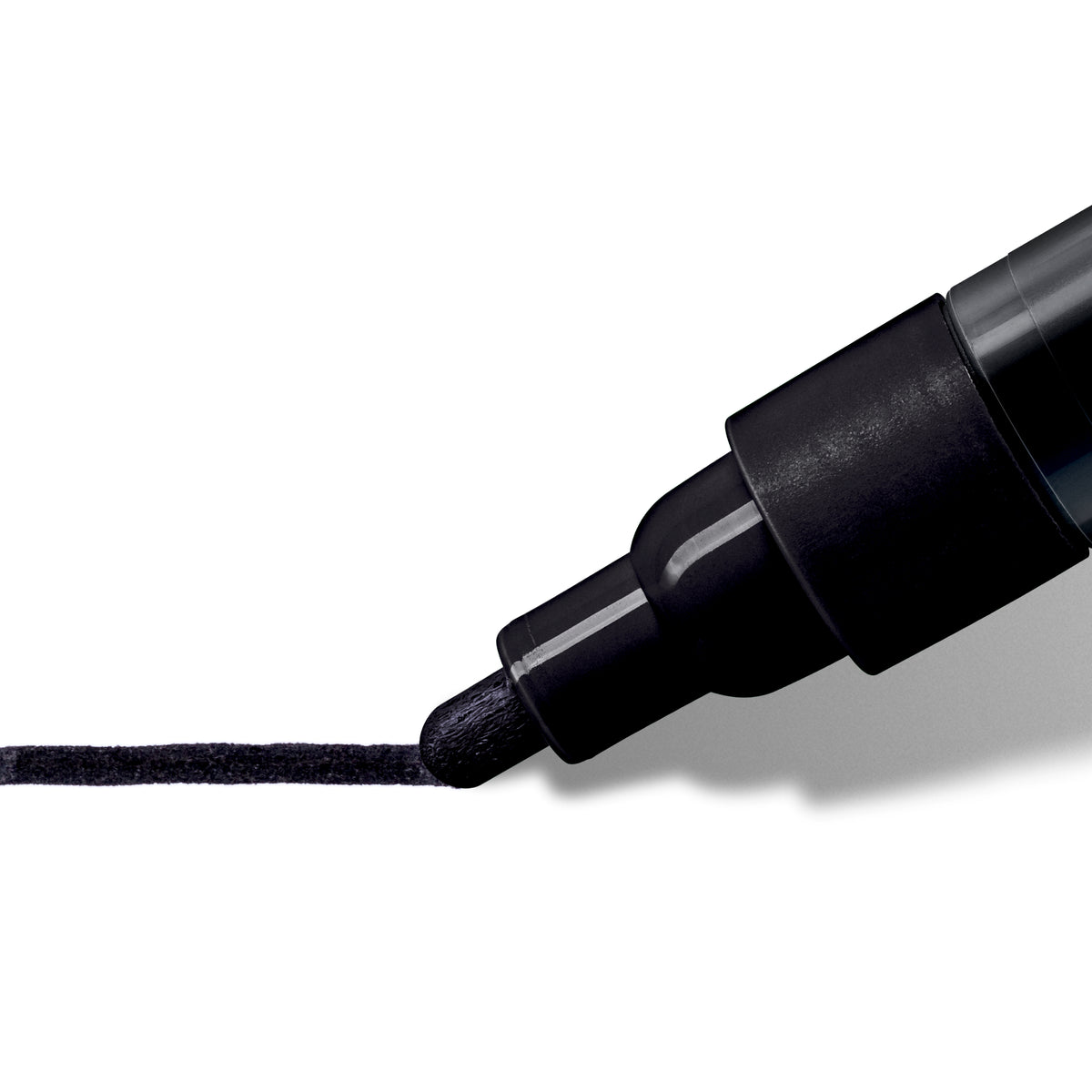 Extreme close up of the black bullet tip laying down a thick, even black line on white