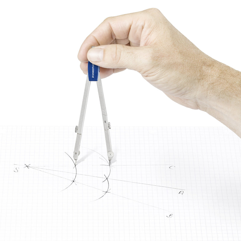 Hand holding the Mars basic compass by its blue head and drawing arcs on squared paper