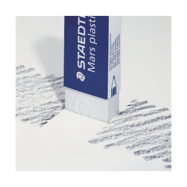A Mars plastic eraser stood on its end beside lines of pencil shading on white paper