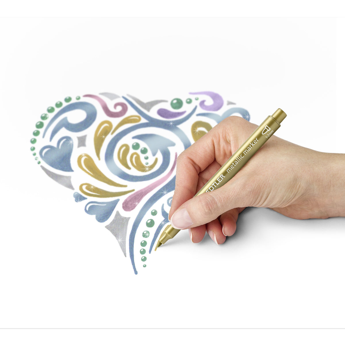 Hand colouring a swirl heart design in metallic shades using a gold pen from the same Staedtler range