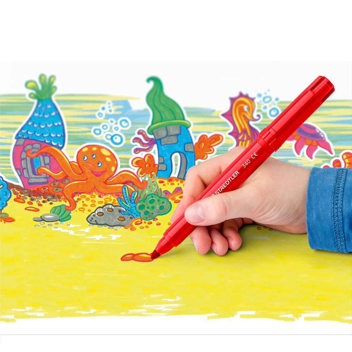 Hand colouring an underwater scene with a red Staedtler 340 jumbo marker, a range photo of the 340 in use