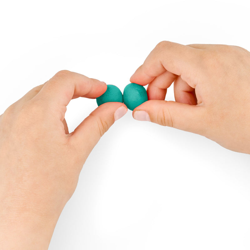 Fingers pressing two small turquoise balls of Noris junior modelling dough together