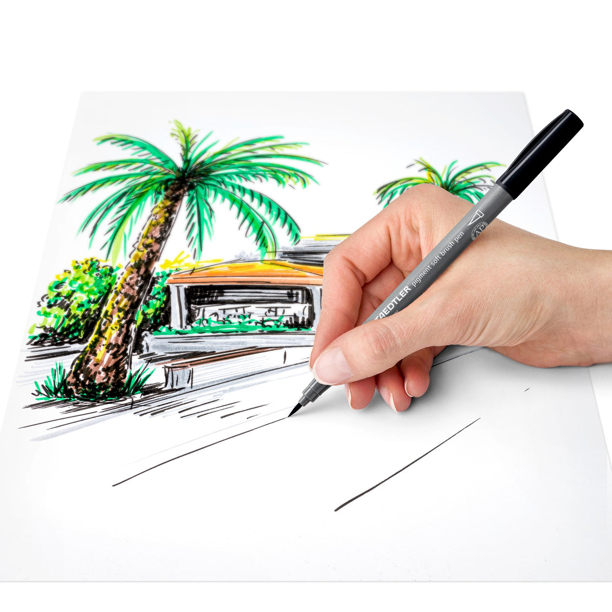Hand sketching palm trees and a building in black with a Staedtler 372 pigment soft brush pen, the soft brush model in this set