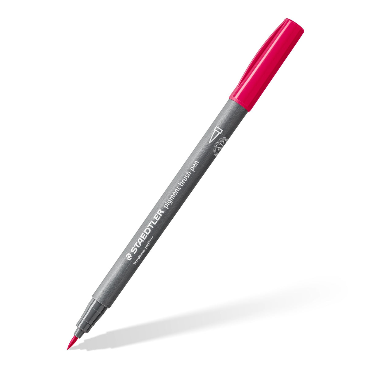 Single Staedtler pigment brush pen with a grey barrel and red cap shown on a slant to reveal the brush nib
