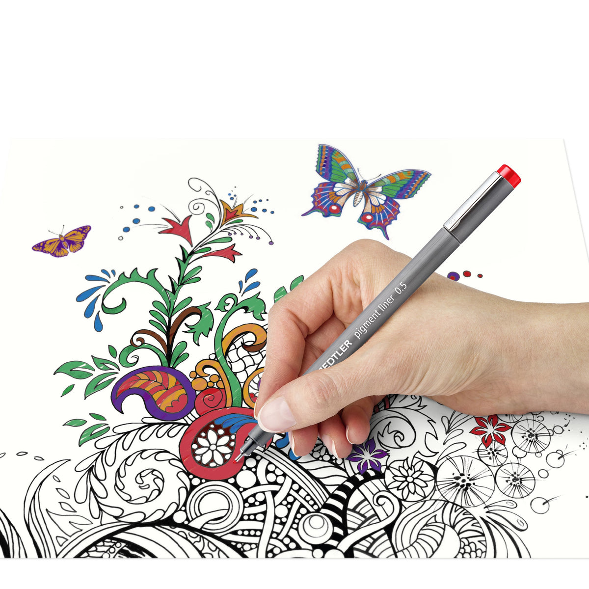 Hand colouring a butterfly and flower drawing with a red Staedtler pigment liner from the set