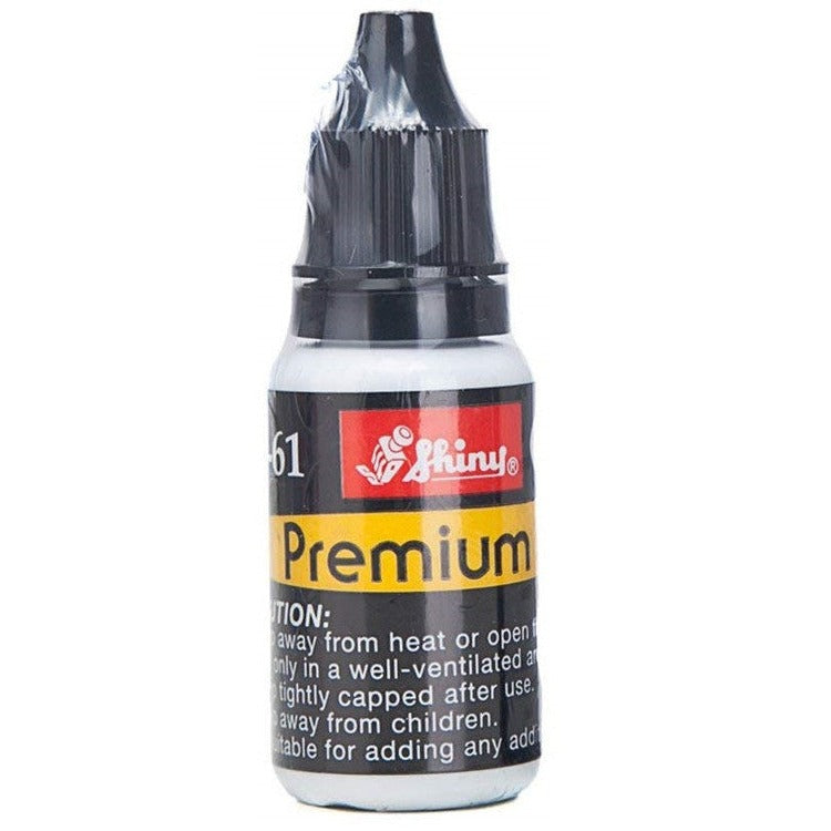 Close view of the Shiny premium ink bottle with a black cap, yellow Premium band and caution text about heat, ventilation and children