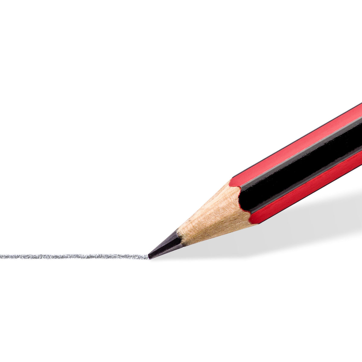 Close-up of a sharpened Staedtler tradition point shading a dark grey graphite line on white paper