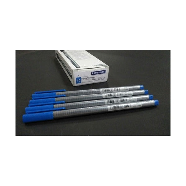 Earlier Staedtler cardboard box of 10 triplus fineliner 334-37 with five ultramarine blue capped pens laid in front on a dark surface