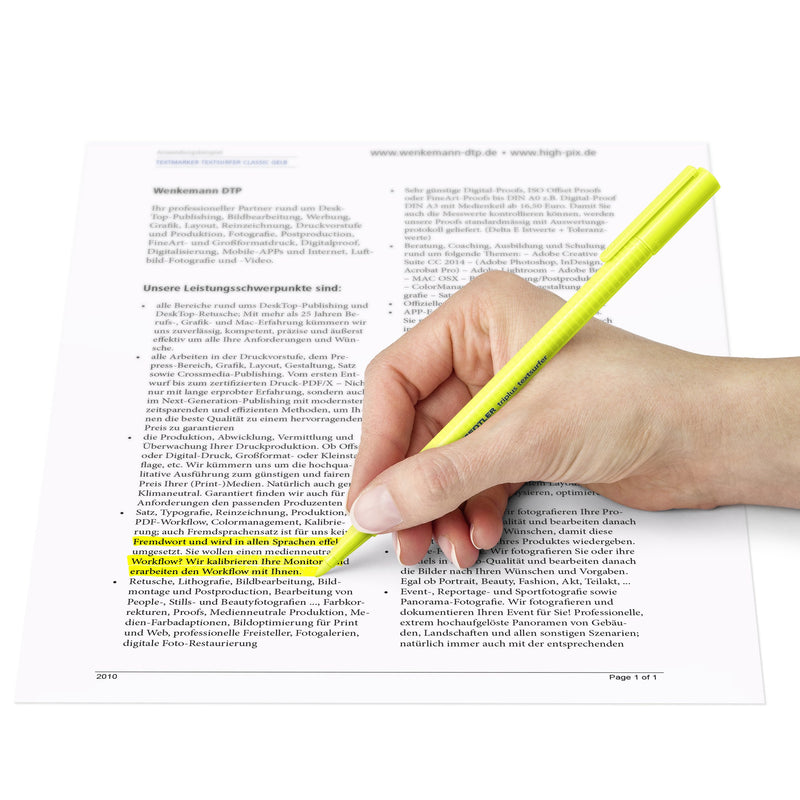 Hand using a yellow triplus Textsurfer on a printed sheet, Staedtler range photo showing how the pen is held
