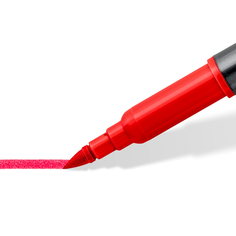 Close view of a red flexible brush tip laying down a broad textured red stroke on white paper