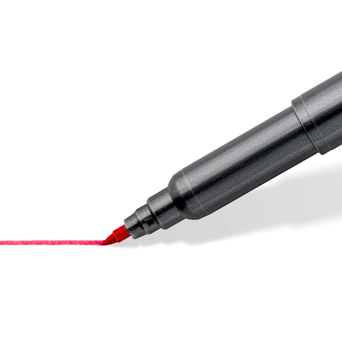 Close view of the fine tip end of a 3001 pen drawing a thin red line on white paper