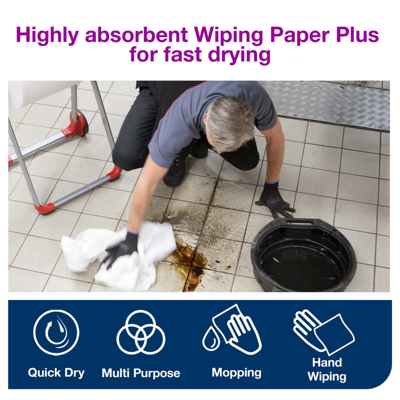 Workshop technician in a grey shirt kneels on white floor tiles and wipes a dark oil spill with white Tork paper, purple heading reading highly absorbent Wiping Paper Plus for fast drying above blue feature icons.