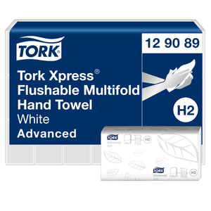 Tork Xpress Flushable Multifold Hand Towel 129089 carton, navy panel reading White Advanced with an H2 badge, beside a white leaf embossed towel bundle in its wrapper