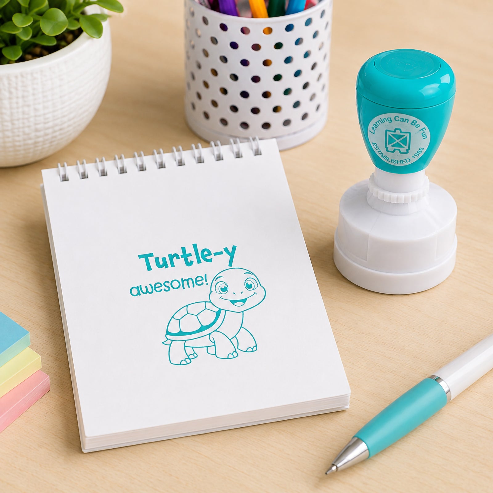 Turtle-y Awesome Merit Stamp shown next to a notepad and pen on a classroom desk. The cheerful turtle design and encouraging message create an engaging way for teachers to recognise student effort and achievement.