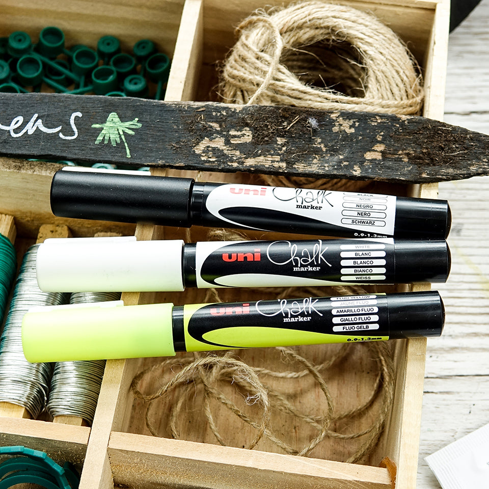 The three PWE-3MS colours, black white and fluorescent yellow, laid in a wooden crate