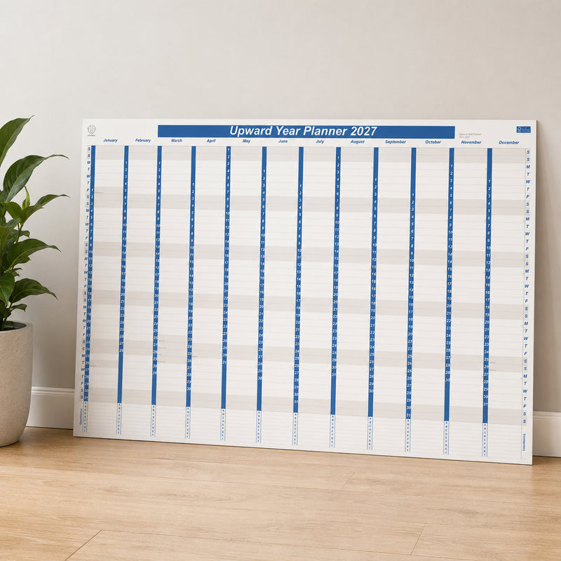 The Upward 2027 Year Planner is displayed upright against a wall in a modern office environment. Its oversized year to view layout is easy to read from a distance, making it suitable for team planning, office scheduling and keeping important annual milestones visible throughout the year.