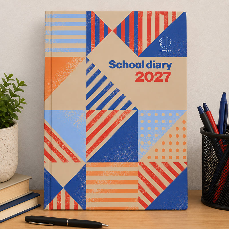Front facing view of the Geometry design school diary positioned on a study desk beside books, pens and a desk organiser. The colourful cover and professional layout showcase its suitability for organised academic planning.