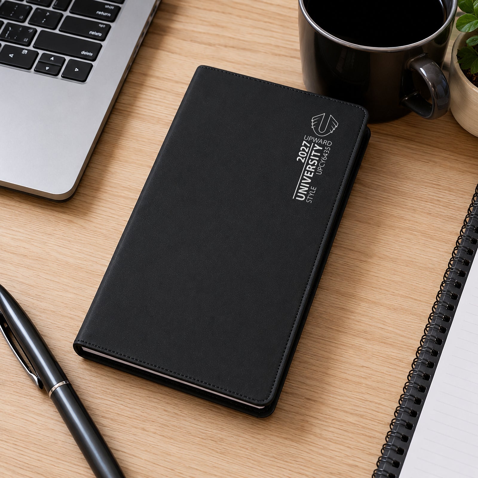 The diary rests on a desk beside a laptop, notebook, pen and coffee mug. This image highlights its practical size and portability, showing how easily it integrates into daily study sessions, office tasks and personal organisation routines.