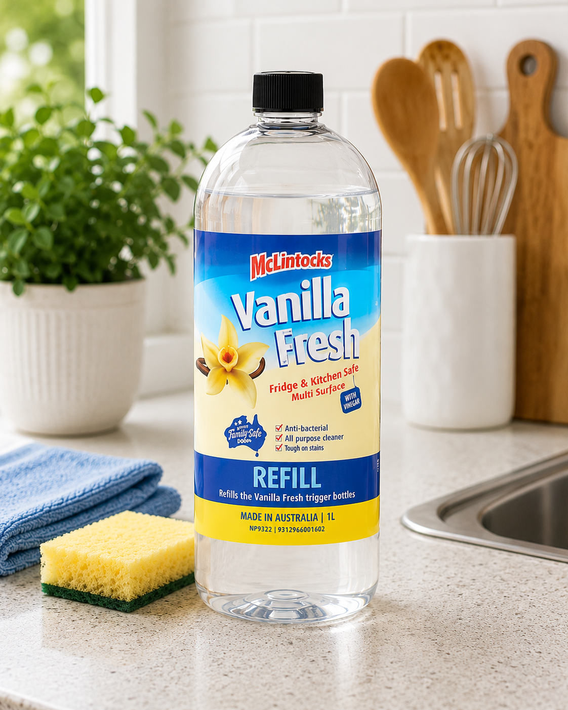 Vanilla Fresh 1 litre refill cleaner bottle displayed on a bright kitchen countertop with cloth, sponge and utensils nearby.