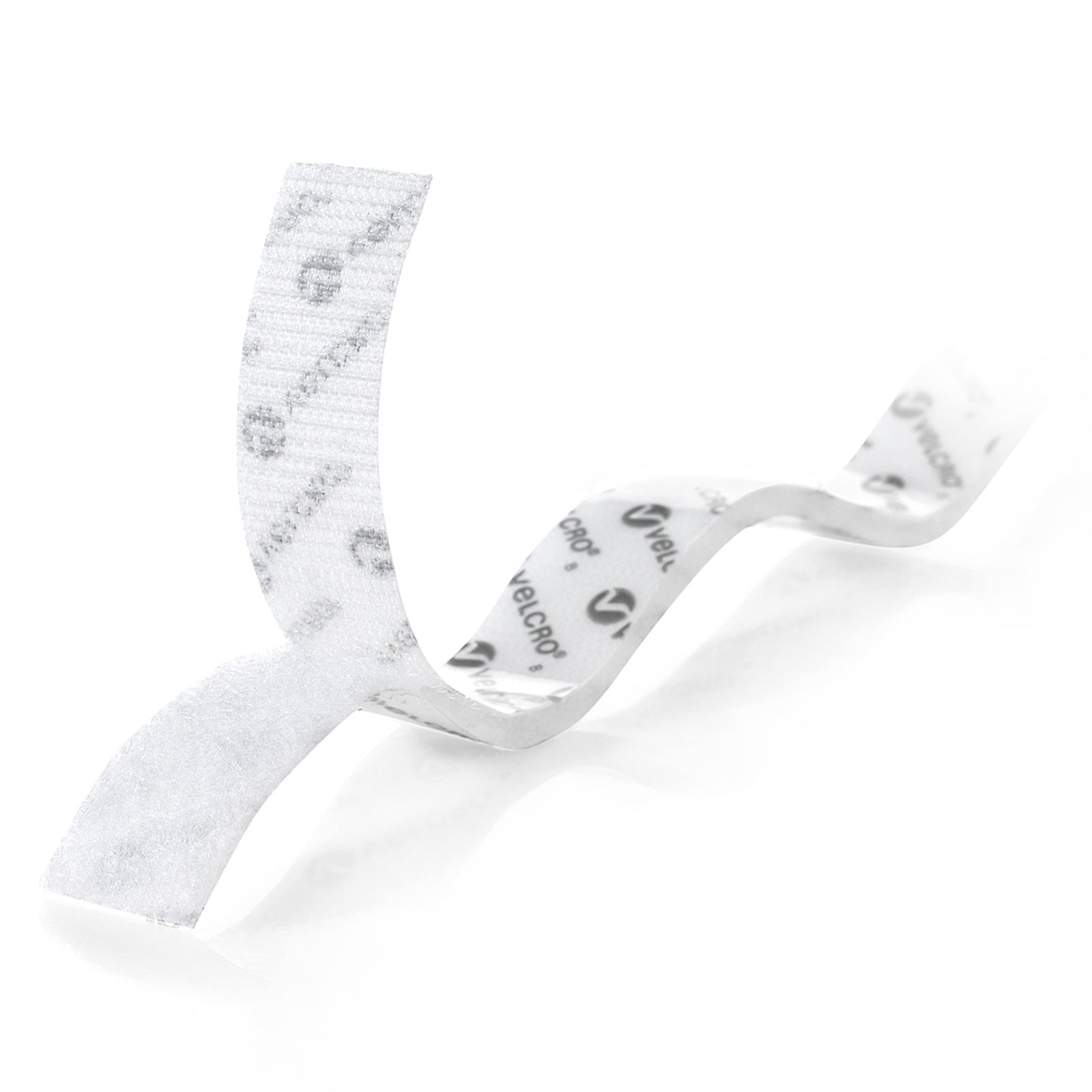 Close up image of white Velcro Brand stick on hook tape with adhesive backing partially peeled away, highlighting flexible material and easy peel and stick application for indoor projects.