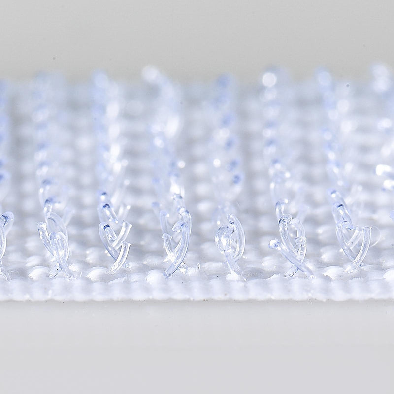 Extreme close up photograph of transparent white VELCRO Brand hook fasteners showing detailed hook texture designed for strong reusable indoor fastening.
