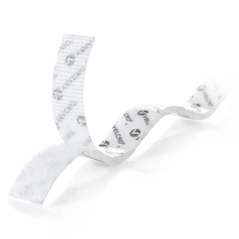 Close up of white Velcro hook and loop tape with visible adhesive backing and fastening surfaces. The image highlights flexible peel and stick construction for general purpose indoor organisation tasks.