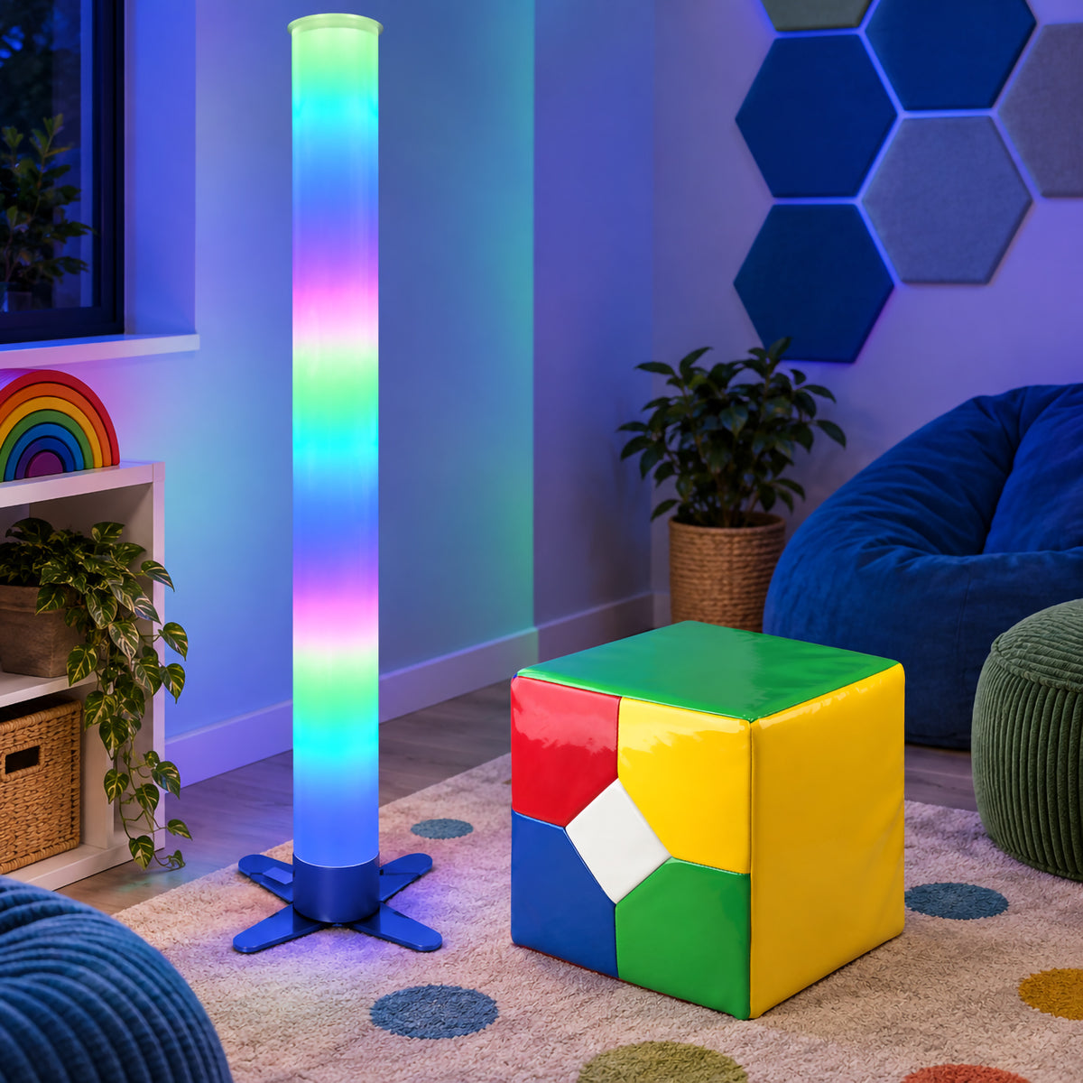 MTA Essentials 183cm Waterless LED Tube displayed with the Extra Large Remote Cube in a calm sensory room. The tall acrylic tube glows with changing blue, green, pink and purple colours beside the brightly coloured cube, demonstrating how the complete kit can create an immersive visual focal point for classrooms and sensory environments.