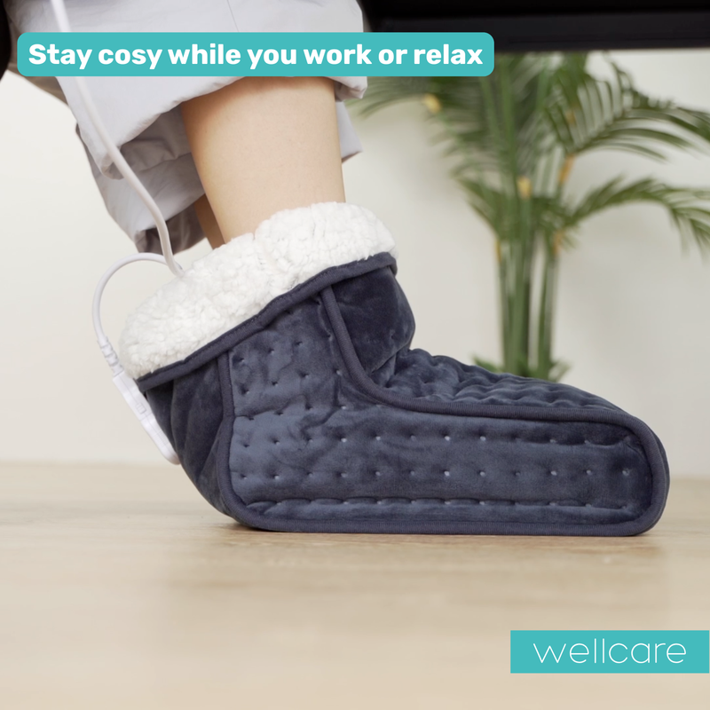 Foot resting in the Wellcare electric foot warmer on a floor, with text about staying cosy while you work or relax