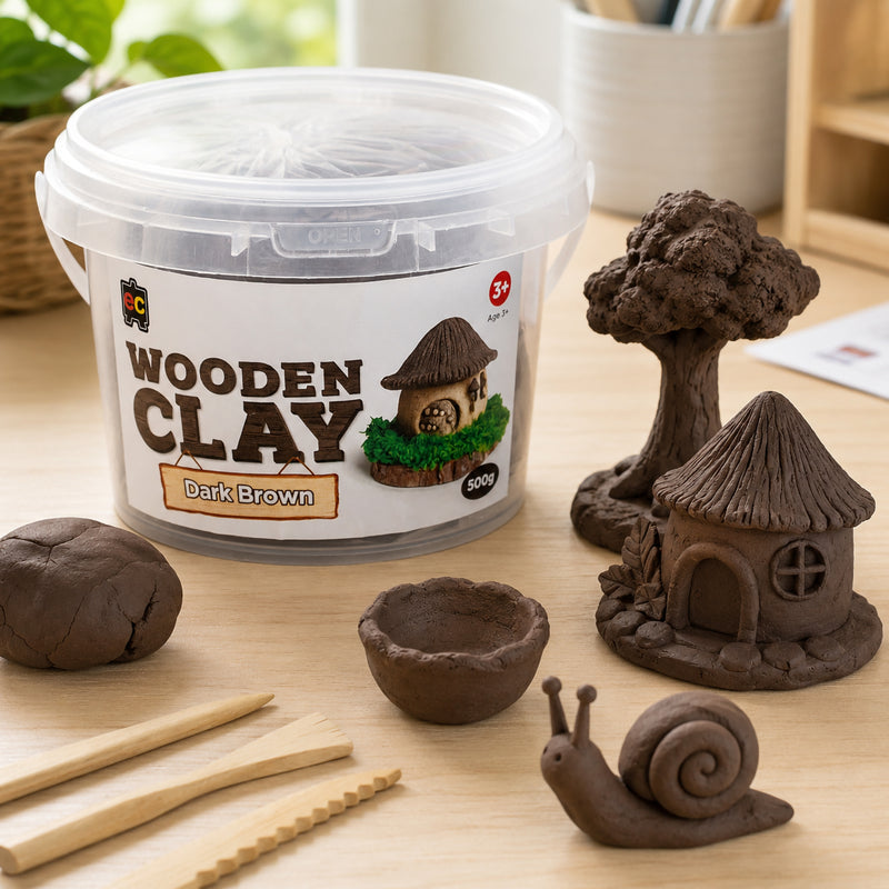 Wooden Clay 500g Dark Brown tub displayed with creative clay sculptures including a tree, fairy cottage, bowl and snail figure. Wooden sculpting tools and textured clay pieces demonstrate the versatility of the modelling clay for artistic projects.