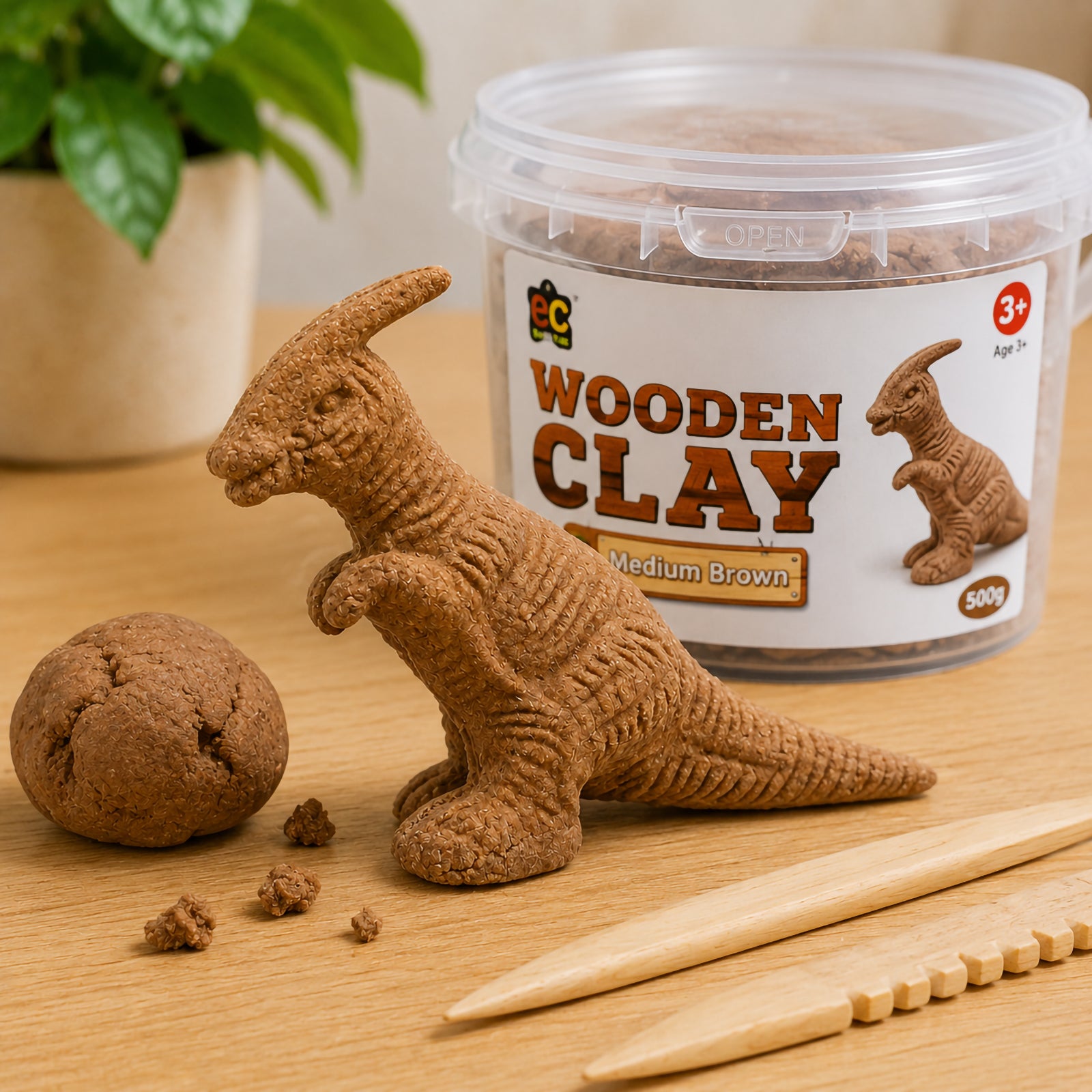 Educational Colours Wooden Clay Medium Brown displayed beside a detailed dinosaur sculpture with textured surface patterns. Wooden sculpting tools and natural brown clay pieces highlight the realistic timber inspired appearance and creative sculpting possibilities.