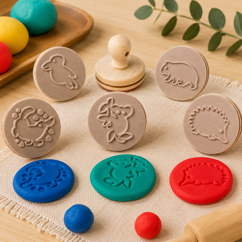 Close up view of Educational Colours Australian animal wooden dough stamps displayed on a soft fabric mat with colourful dough impressions showing koala, echidna, platypus, wombat, and kookaburra designs for sensory learning activities.