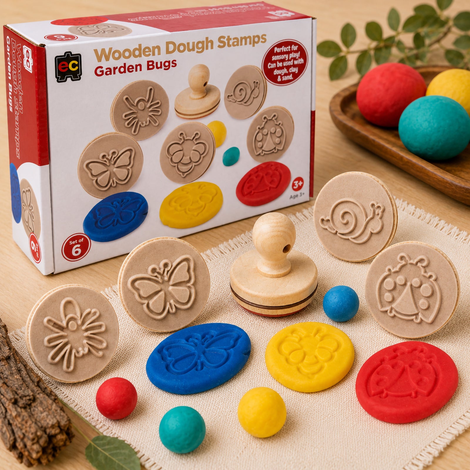 Complete Wooden Dough Stamps Bugs set displayed beside retail packaging with colourful dough impressions featuring butterfly, bee, snail, spider, dragonfly, and ladybug designs for sensory learning activities.