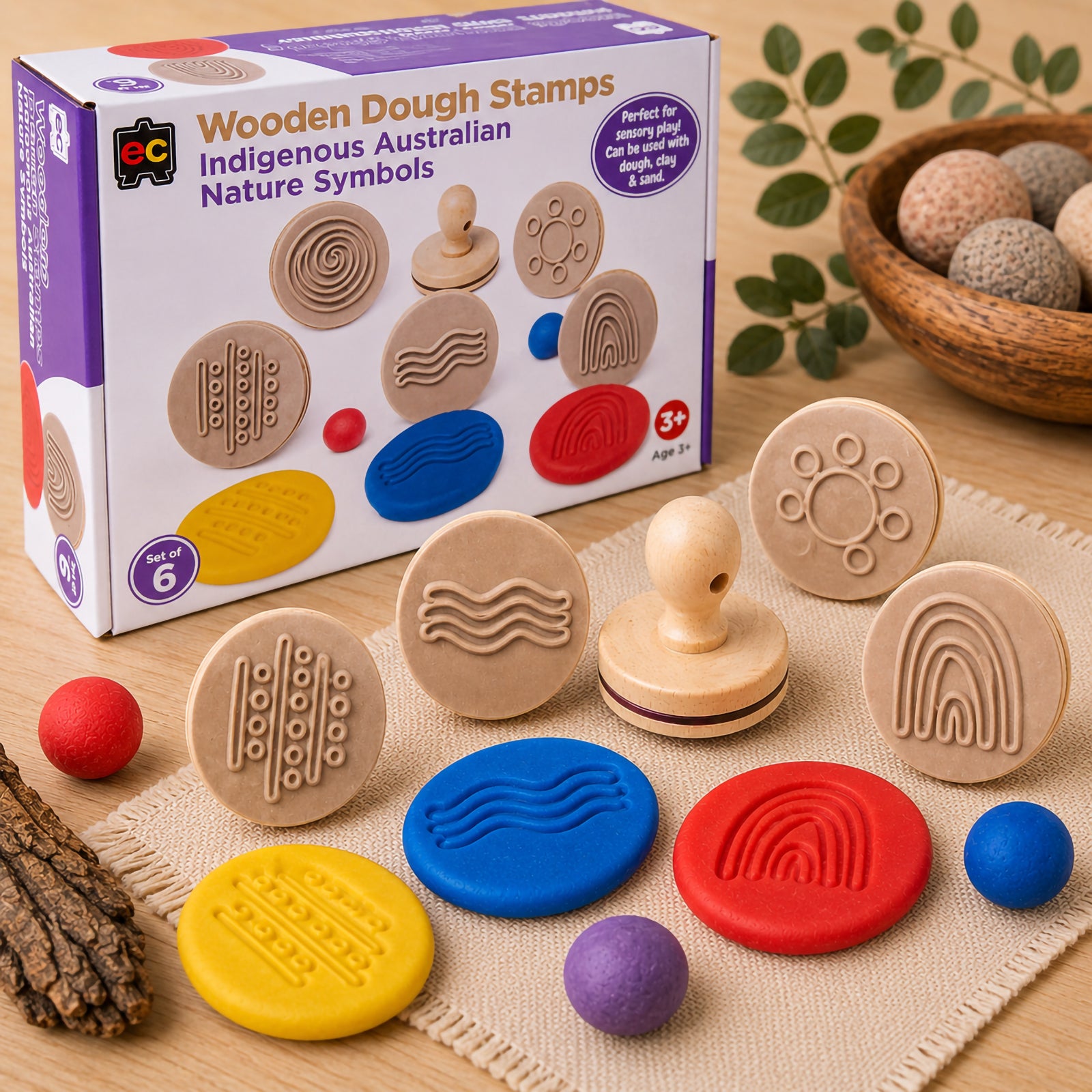 Educational Colours Wooden Dough Stamps Indigenous Australian Nature Symbols set displayed with retail packaging, wooden symbol stamps and colourful dough impressions on a textured mat. The image highlights sensory activities and cultural learning through tactile play for children.